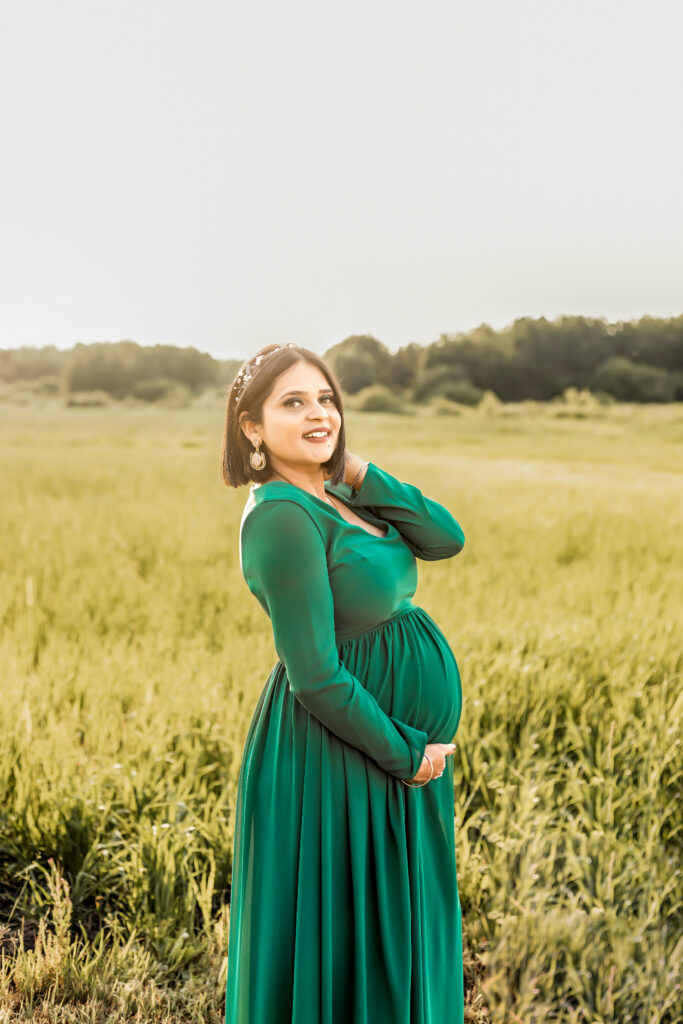 Pregnant woman with a visible baby bump looking happy