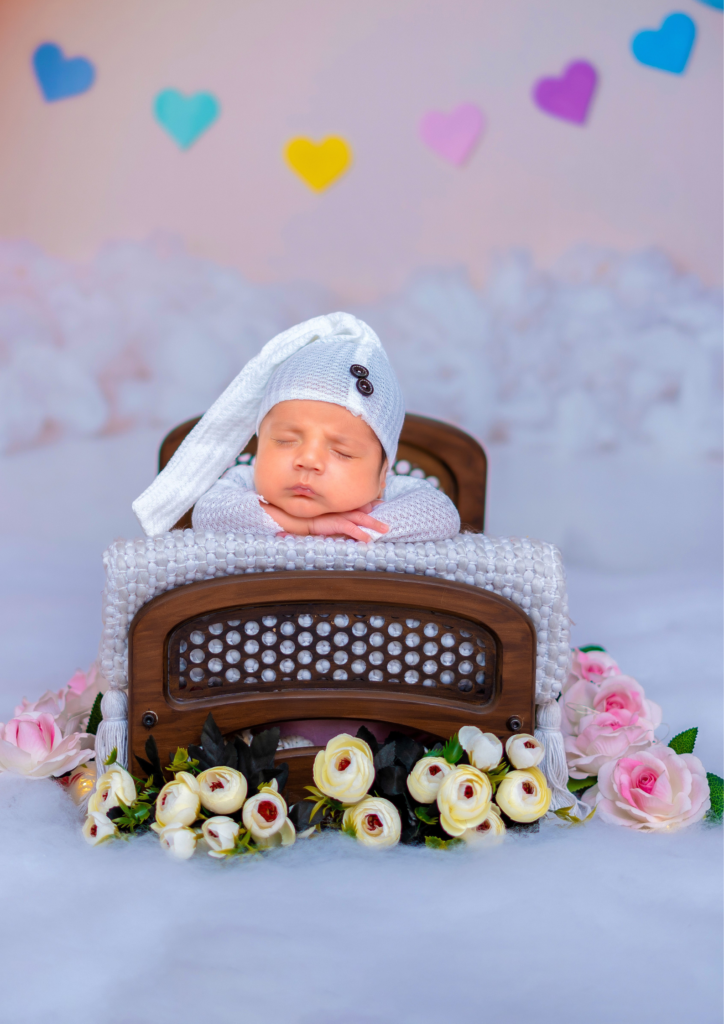 newborn baby wearing white clothes and cap sleeping on a small bed