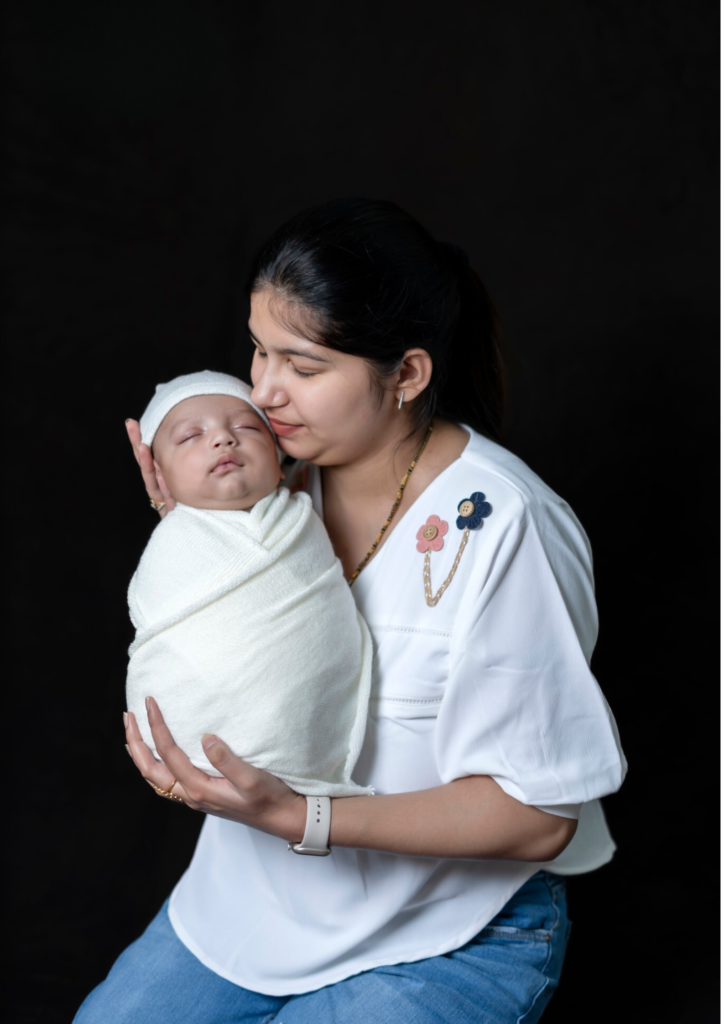 a women holding her baby in her hands and kissing her baby's face