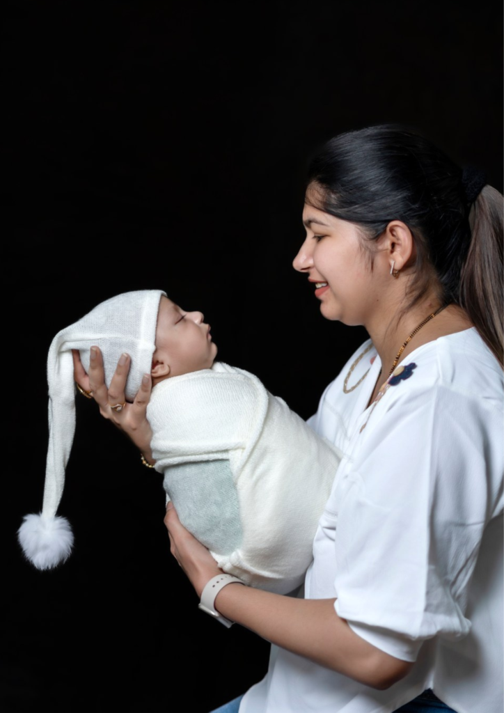 a women holding her baby in her hands looking towards her baby's face