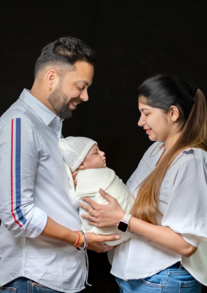 mother and father holding their baby in their hands looking happy and joyful