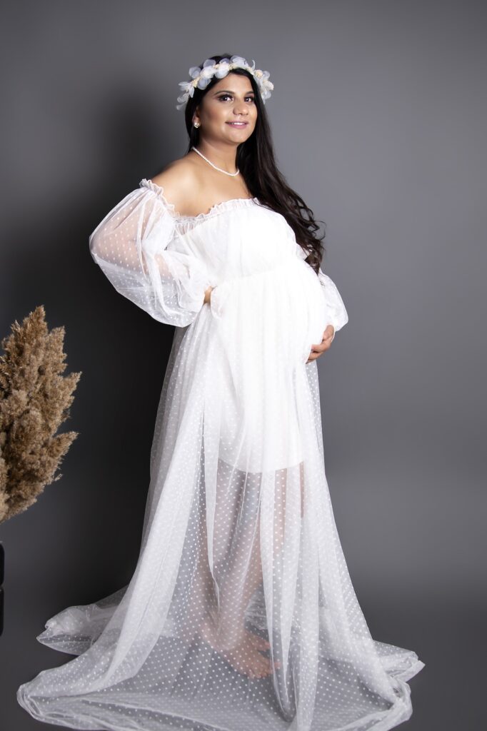 a pregnant women wearing white dress and white flowery hairband